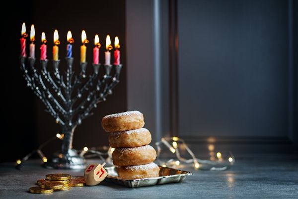 Menorah with all 7 candles lit and some bread cakes for Start of Hanukkah