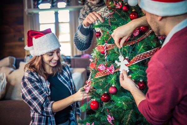 Man and woman decorating a Christmas tree for Tree Dressing Day