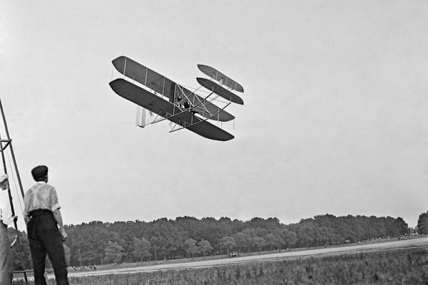 Black and white image of a plane in the sky for Wright Brothers Day