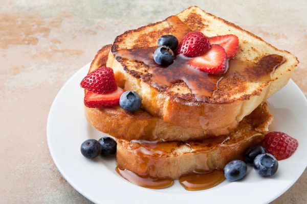 Photo of a stack of french toast with strawberries for french toast day