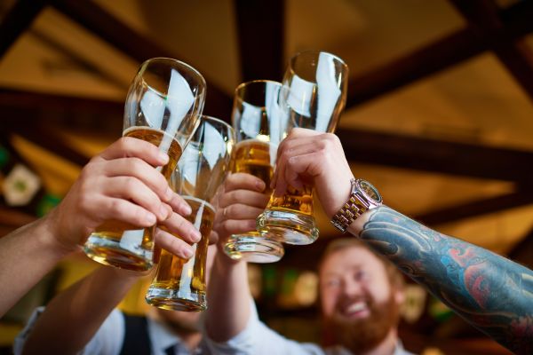 Photo of people raising beer glasses for Happy Hour Day