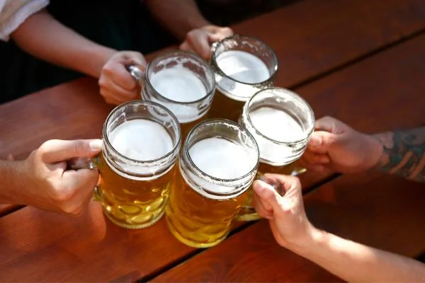 People clinking glass tankards of beer for Oktoberfest beer festival