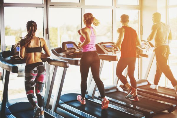 Three people running on treadmills for National Exercise Day