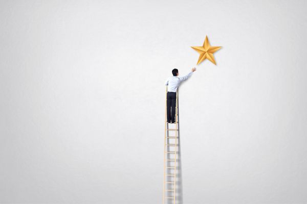 A man climbs a ladder aiming for a star for social mobility day
