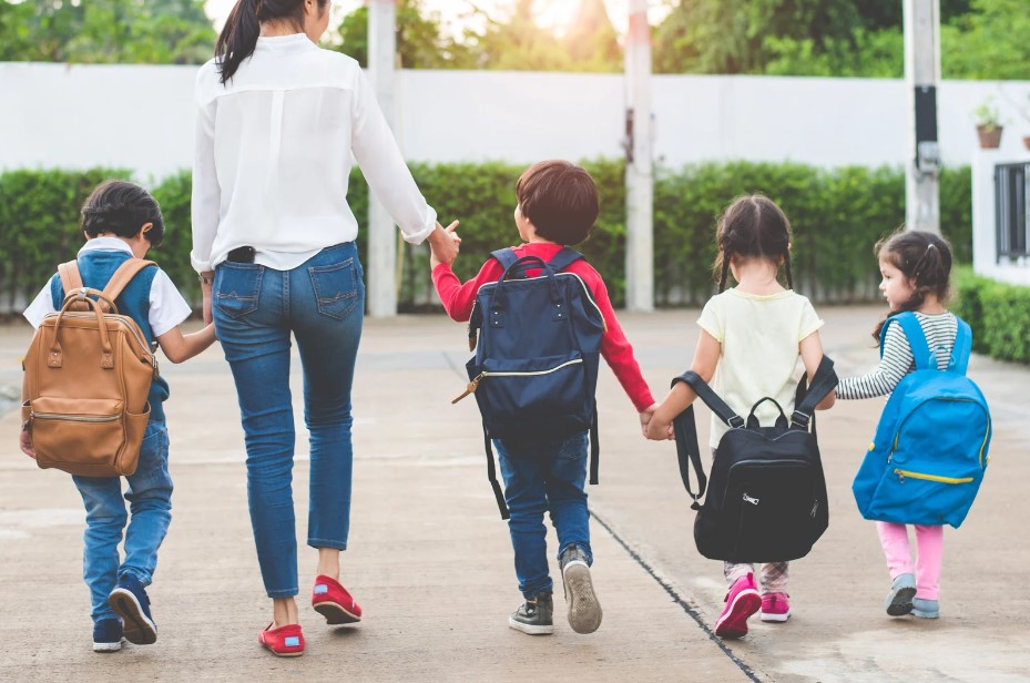 Mother walking to school with four children for Walking to School month