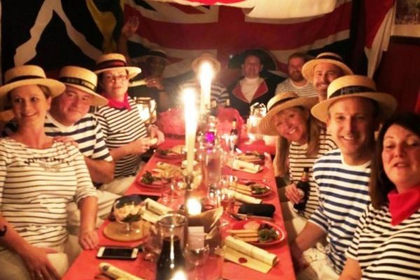 A festive table with people wearing naval clothes to celebrate Pickle Night